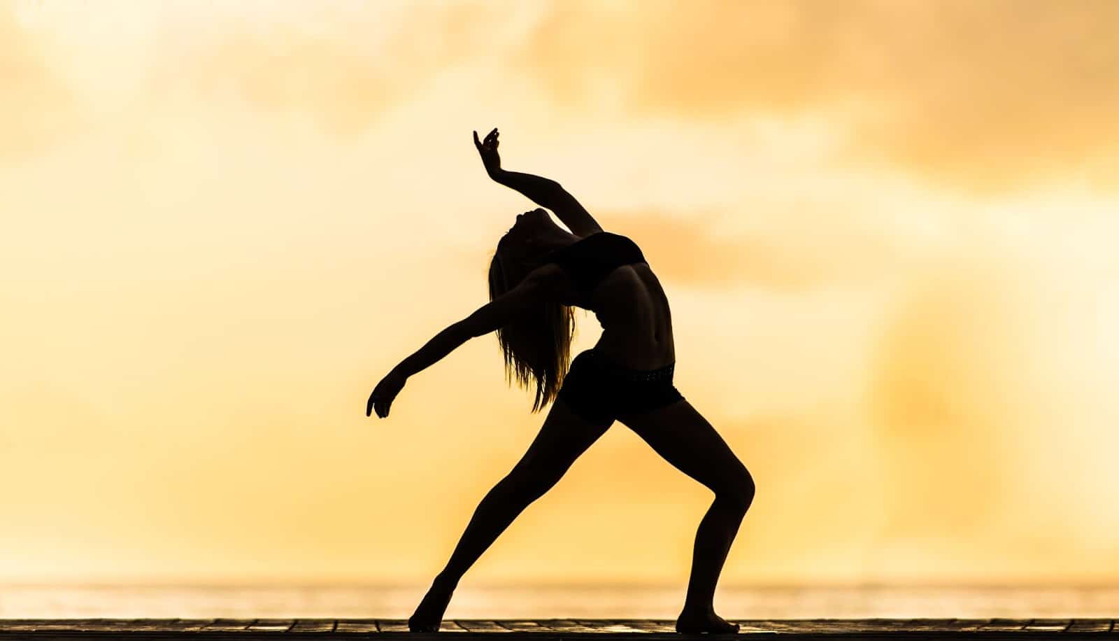 Women Doing Yoga while sunset