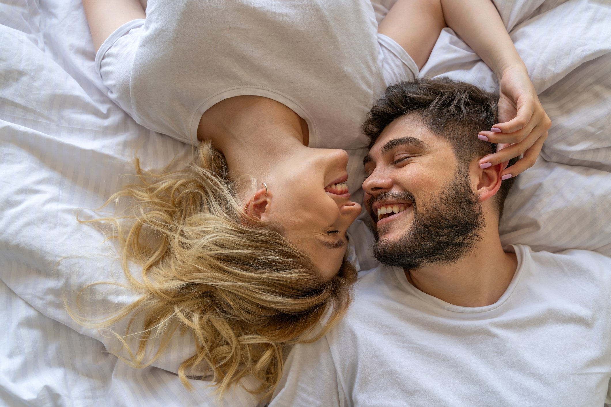 Sweet young couple is laughing in bedroom
